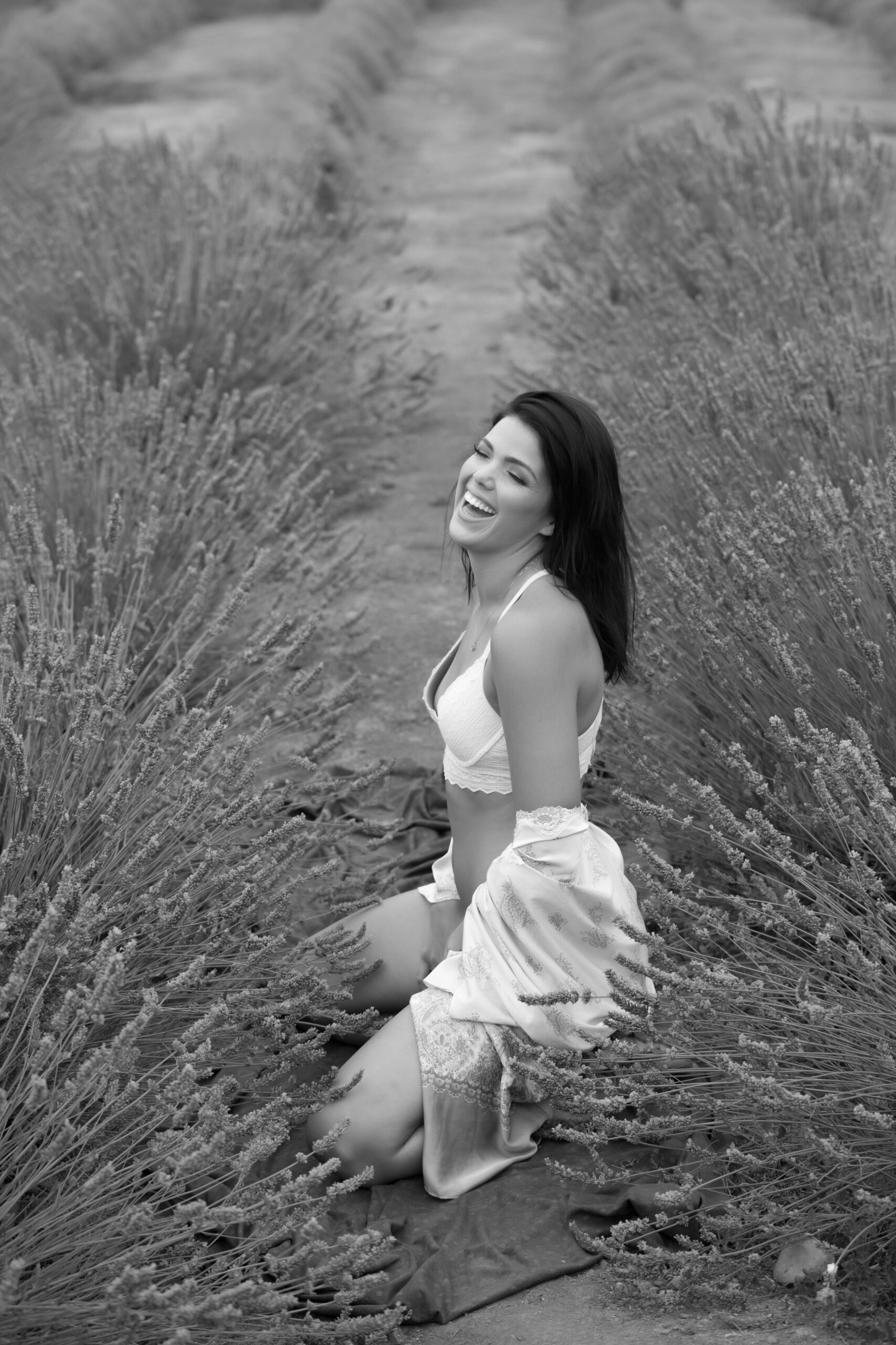 woman laughing enjoying her photography shoot in the lavender field