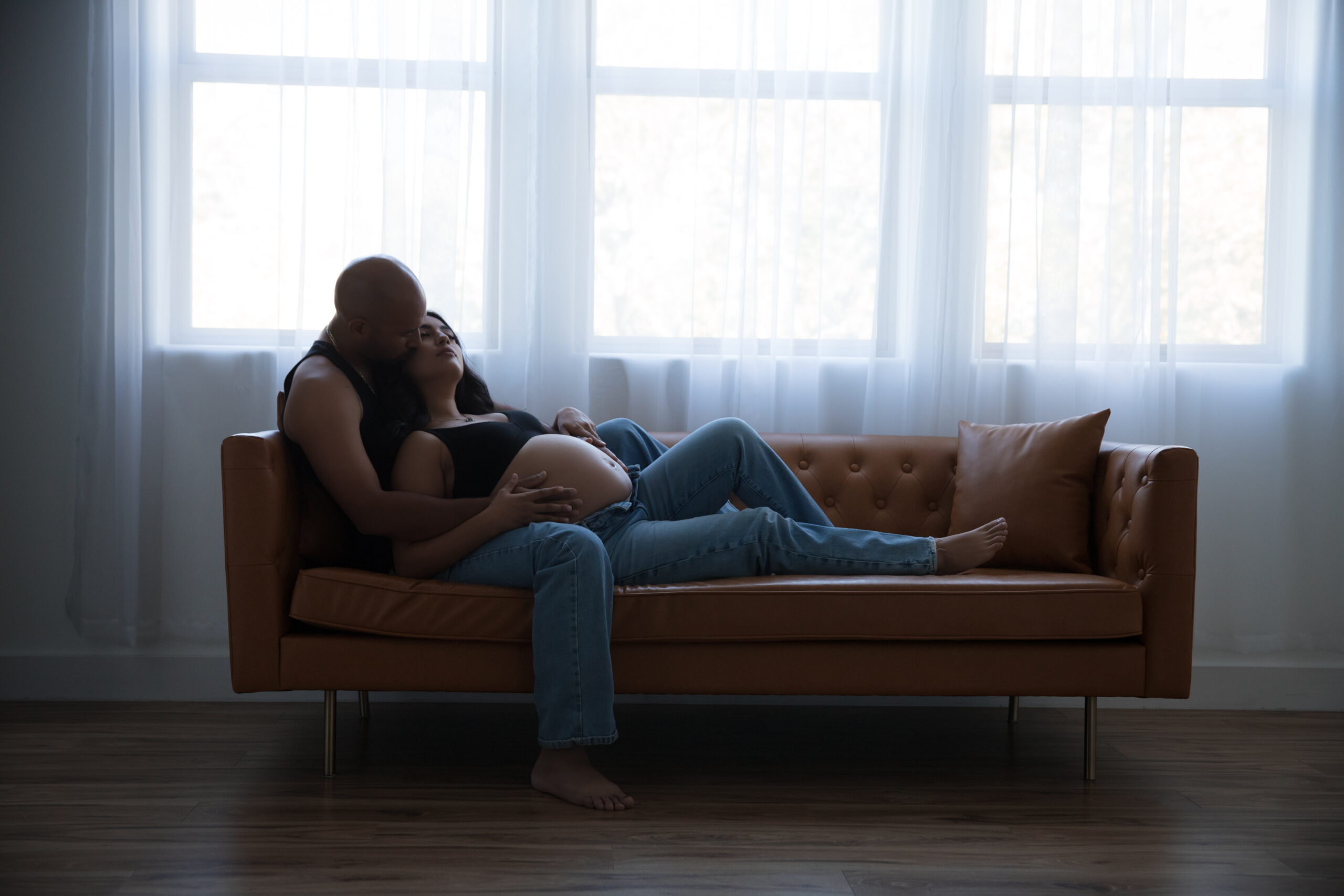 couple cozy on couch maternity photos