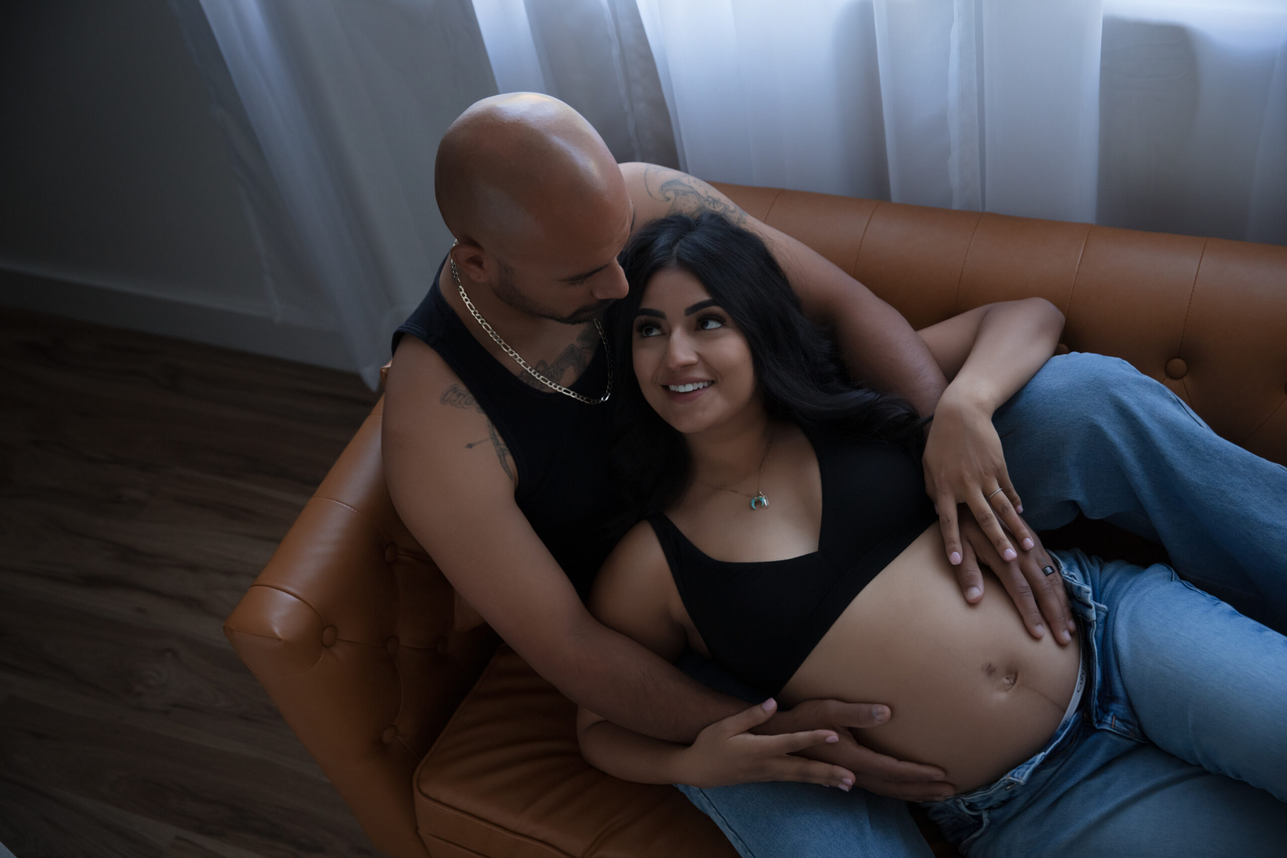 pregnant couple lounging on couch